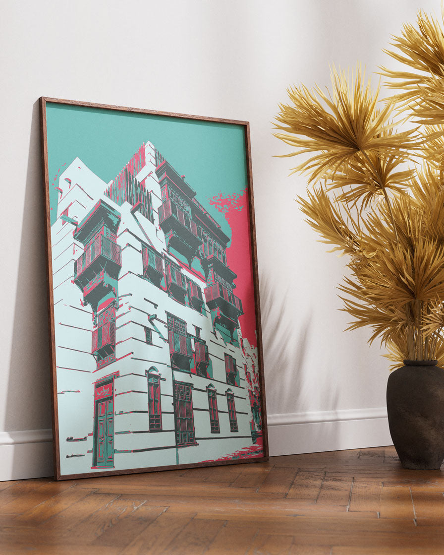 Framed artwork of al balad building on a wall next to decorative plants.