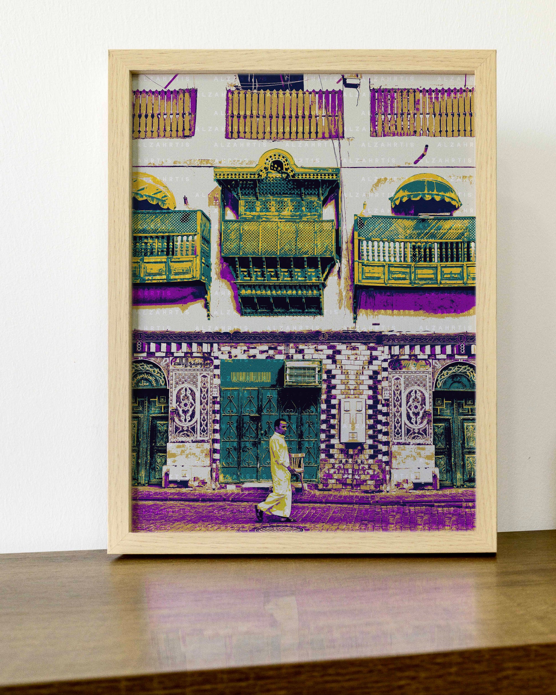 Framed artwork of a colorful street scene with buildings and a person walking.